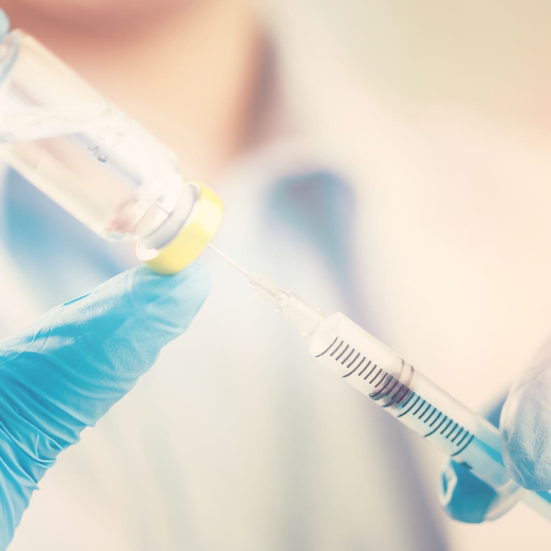 Dettaglio di una siringa che aspira una soluzione medica prima dell'iniezione